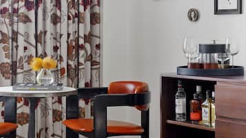 Una habitación con una mesa, sillas, una estantería y una cortina decorativa.