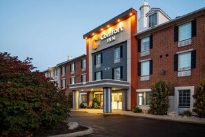 A Comfort Inn hotel with a brick facade, multiple windows, and a well-lit entrance.