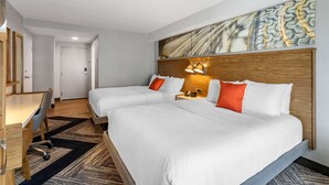 A hotel room with two beds, a desk, and a chair. There is a painting on the wall and a door in the background. - Comfort Inn Sarnia (Sarnia)