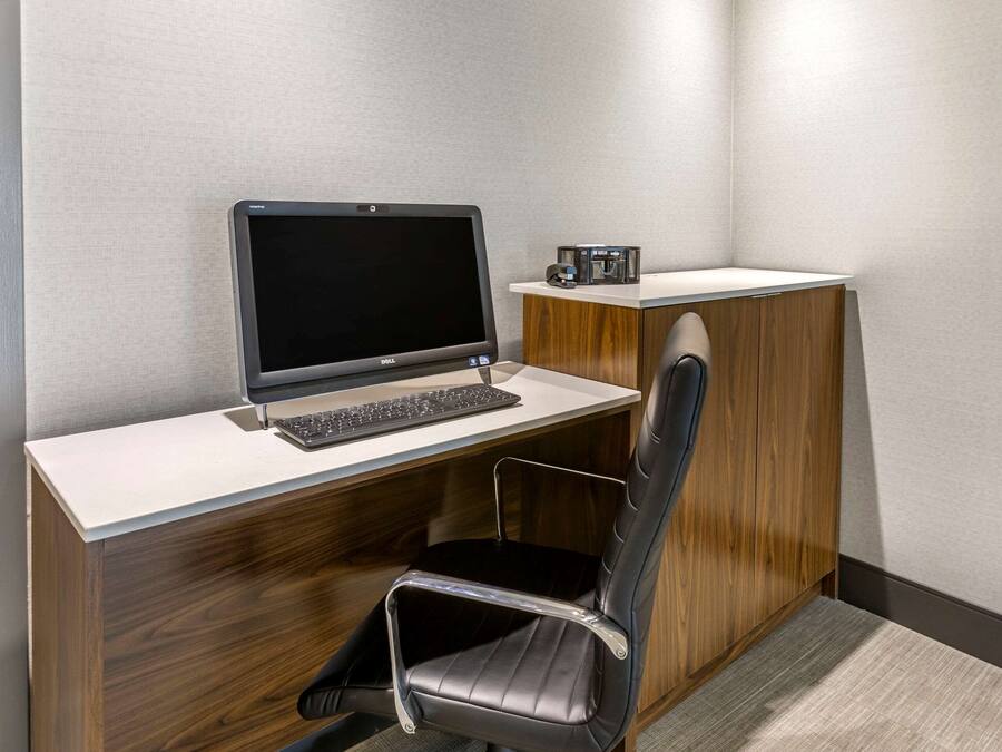 Un espacio de oficina moderno con escritorio, ordenador y silla.