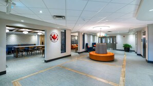 A spacious lobby with a long reception desk, a seating area with a round orange table, and a clock on the wall. - Comfort Inn Sarnia (Sarnia)