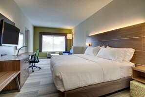 A hotel room with a large bed, a desk with a chair, a television, and a window with natural light. - Holiday Inn Express & Suites Aurora - Naperville by IHG (Aurora)