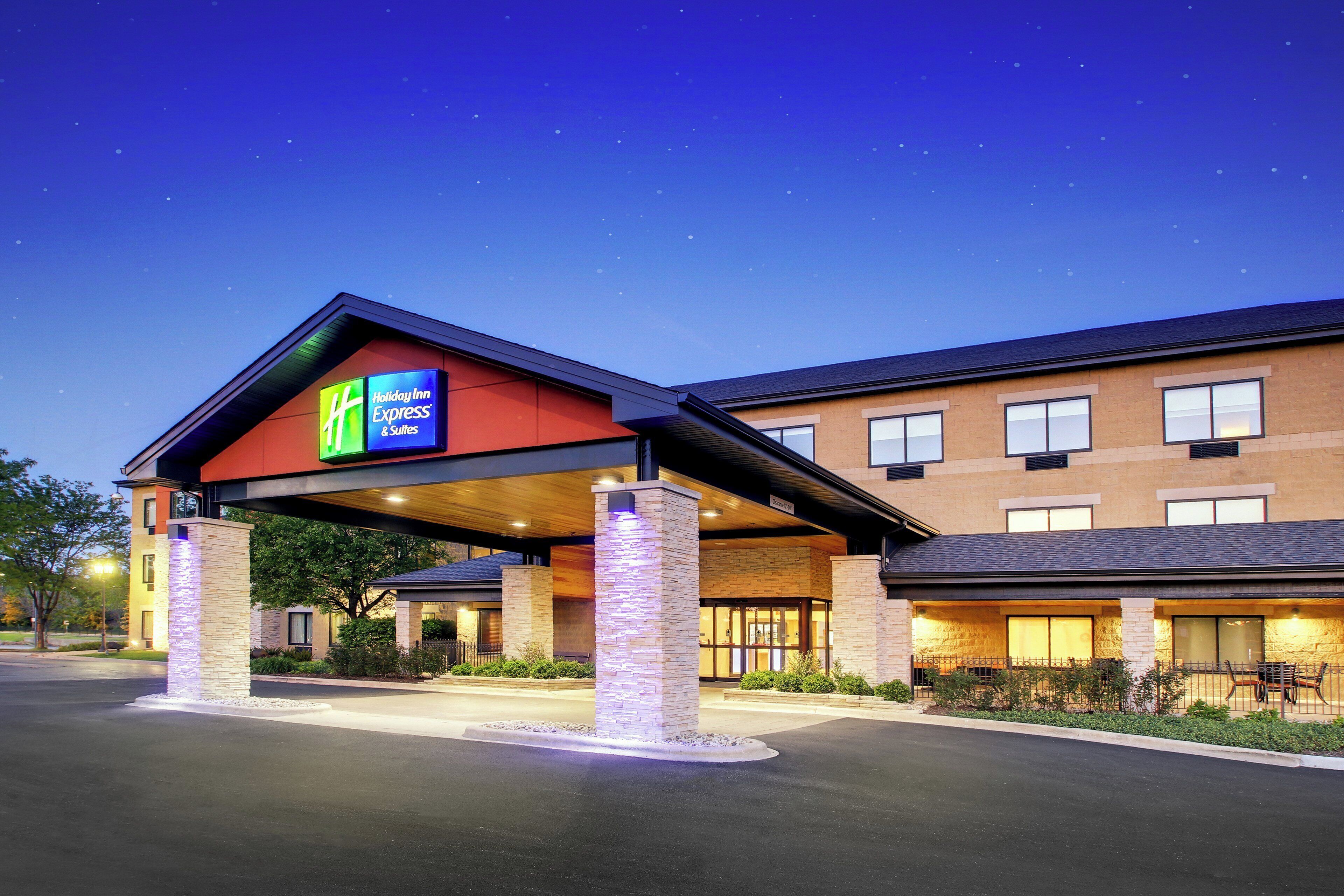 A Holiday Inn Express & Suites building with a covered entrance and a brick facade.