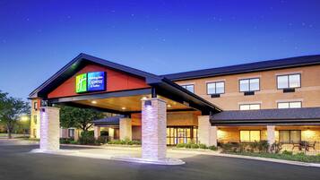 Holiday Inn Express & Suites -hotellin rakennus, jossa on katettu sisäänkäynti ja tiiliverhoiltu julkisivu.