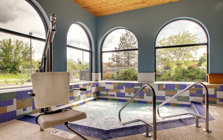 A spa area with a pool, a chair, and a view of the outdoors.