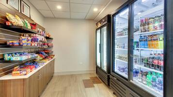A grocery store interior with refrigerated beverage cases and shelves stocked with snacks and beverages.