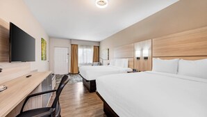 A hotel room with two beds, a desk with a chair, a flat-screen TV, and a large window with curtains. - The Bradford Hotel, an Ascend Collection Hotel (Springfield)