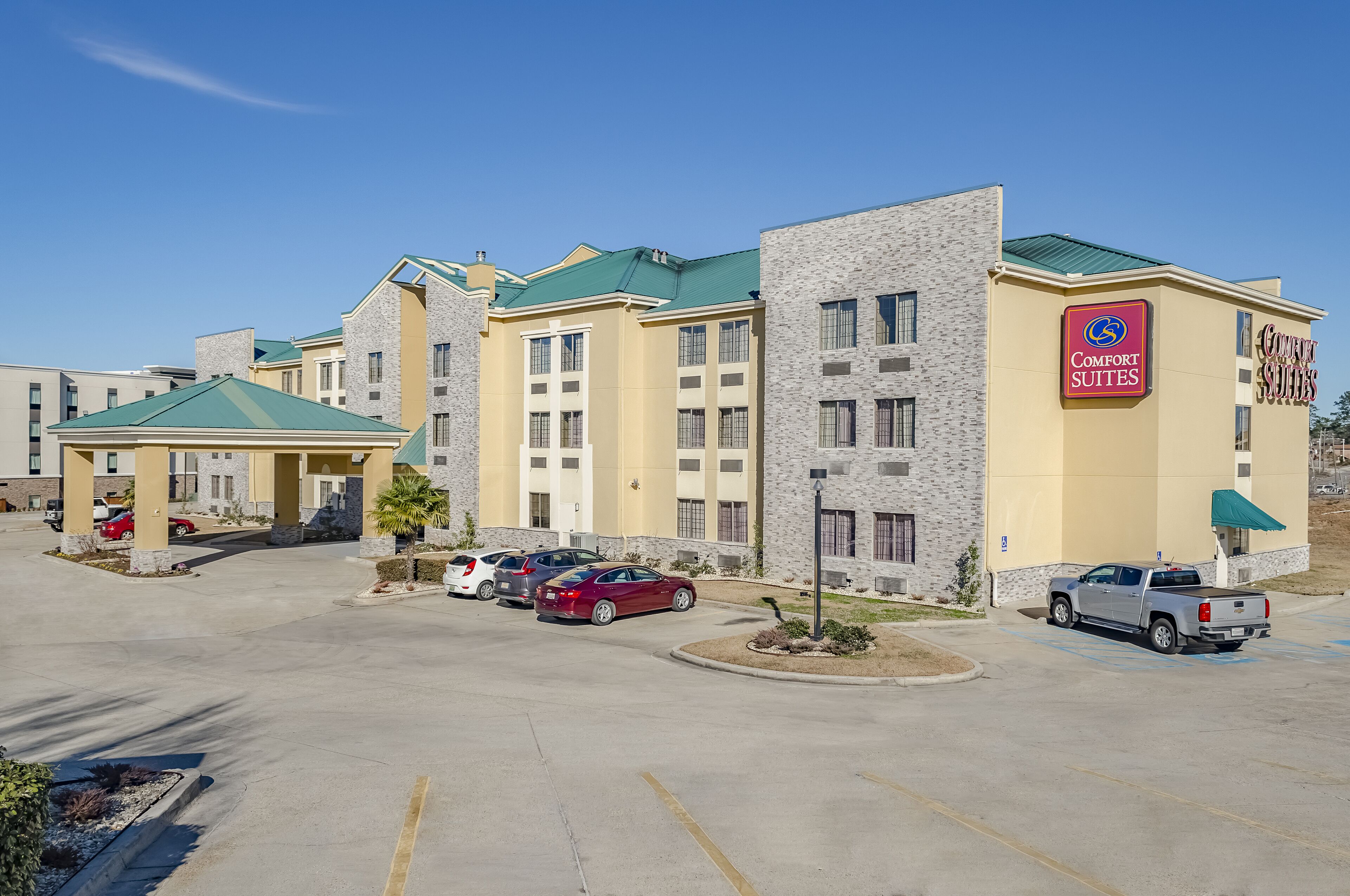 A hotel with multiple buildings, a parking lot, and a Comfort Suites sign.