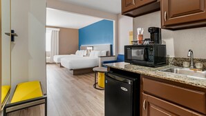 A hotel room with a bed, a small kitchenette with a microwave, a sink, and a compact refrigerator. - Comfort Suites Hattiesburg near University (Hattiesburg)