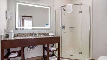 Ein Badezimmer mit Duschkabine, Waschtisch mit Spiegel und Toilette.