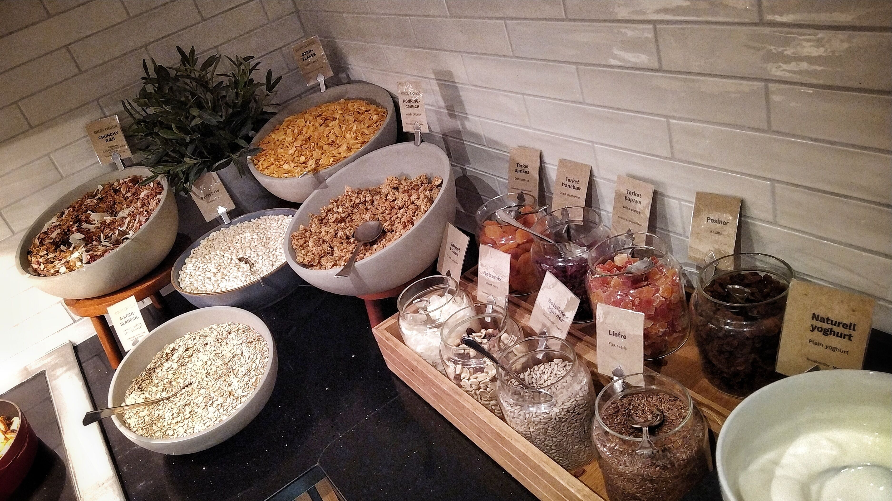 Un bufé con diferentes opciones de comida, como cereales, frutas secas y frutos secos.
