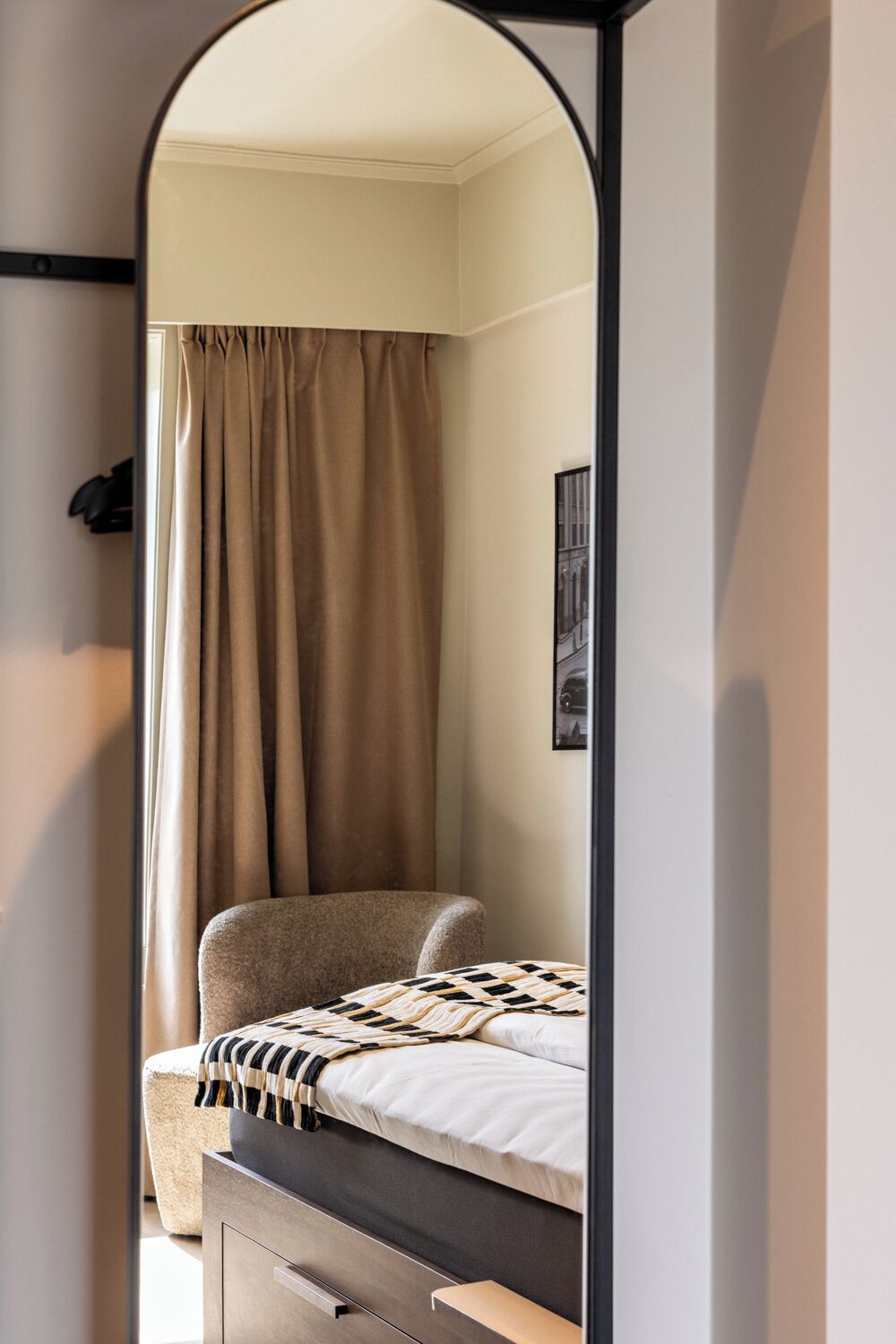 Une chambre à coucher avec un lit, une chaise, une armoire et un miroir.