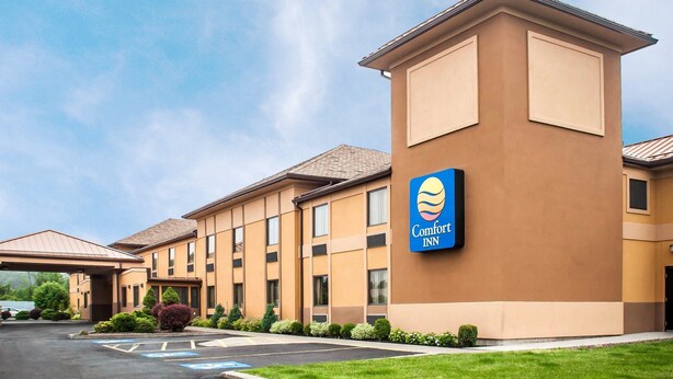 Un hotel Comfort Inn con un diseño moderno, que incluye un techo plano y un amplio estacionamiento.