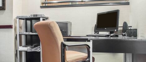 A compact office space with a desk, two monitors, a chair, and a bookshelf.