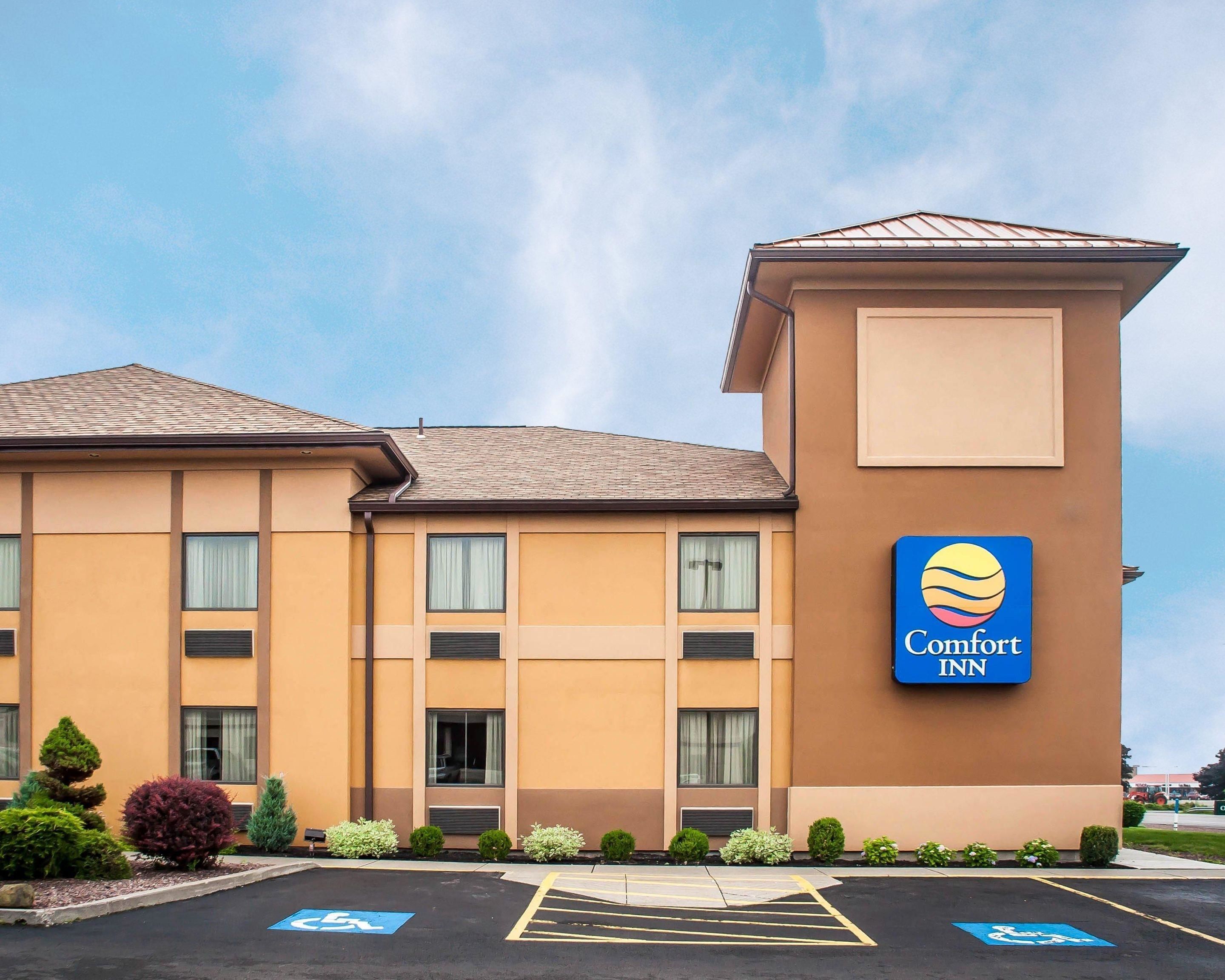 Een Comfort Inn hotel met een parkeerplaats, daar zijn parkeerplaatsen gereserveerd voor mindervaliden, en een heldere lucht.