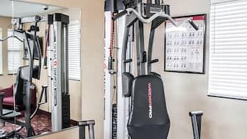 A gym with a pull-up bar, a weight bench, and a wall calendar.