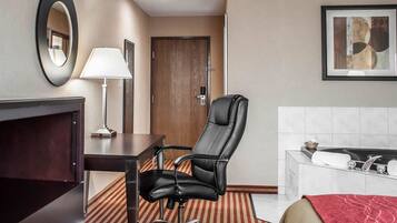 Une chambre d’hôtel équipée d’un bureau, d’une chaise, d’une lampe et d’un grand miroir.