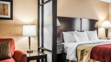 A hotel room with a bed, bedside tables, a desk, a chair, and a lamp.