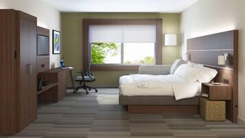 A bedroom with a bed, a desk, and a wardrobe.