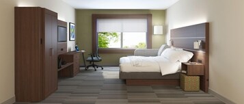A bedroom with a bed, a desk, and a wardrobe.
