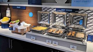 A buffet setup with labeled sections for fruit, hot food, and a sign indicating a hot start. - Holiday Inn Express Canton by IHG (Canton)