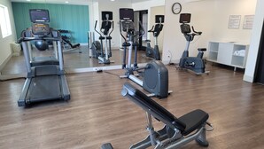 A gym with treadmills, elliptical machines, and a bench press area. - Holiday Inn Express Canton by IHG (Canton)