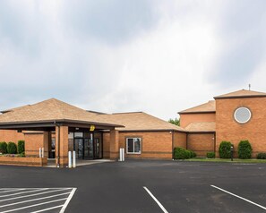 A building with a brick facade, a covered entrance, and a parking lot. - Quality Inn Clarion (Clarion)