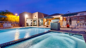 A swimming pool with a tiled edge, lounge chairs, and a fitness area with treadmills and exercise equipment.