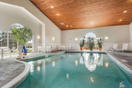 Una piscina techada, sillones reclinables de piscina