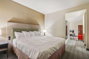 Een hotelkamer met een groot bed, een bureau, een stoel en een televisie.
