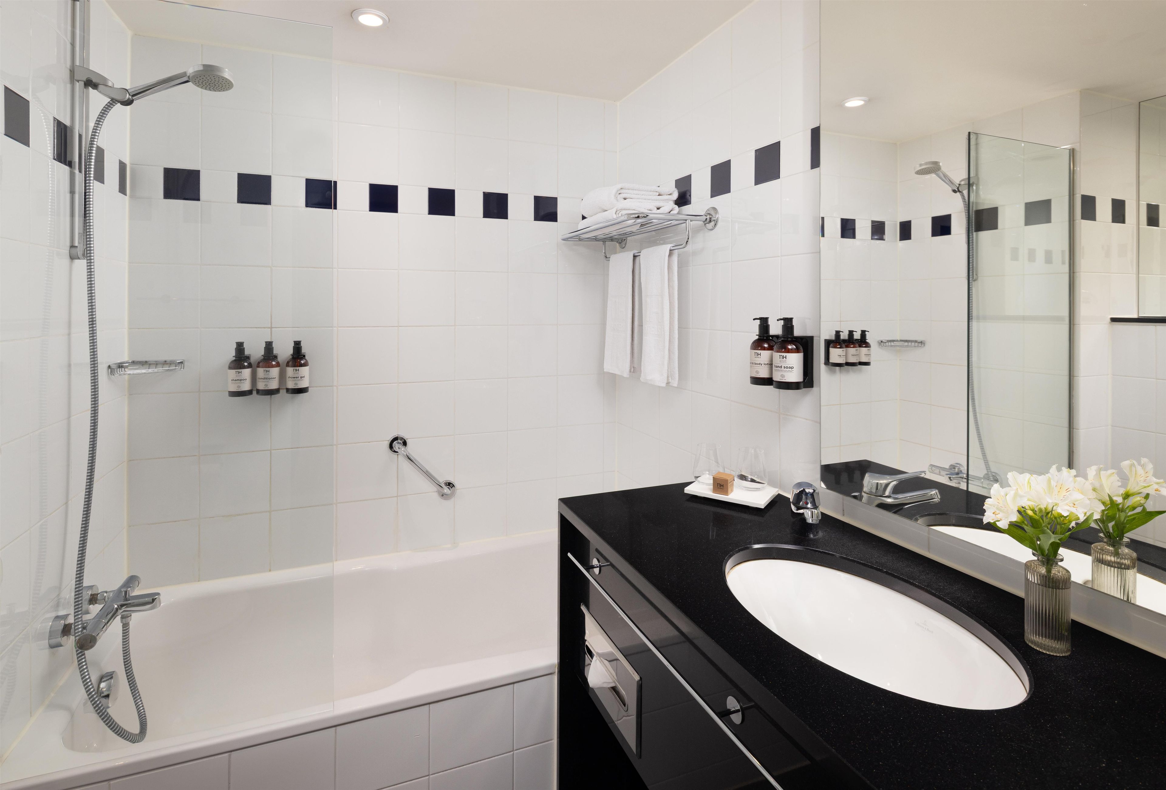 A modern bathroom with a bathtub, a sink, and a shower area.