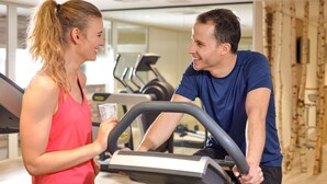 A gym with exercise equipment and a person holding a water bottle. - Dorint Am Nürburgring Hocheifel (Nuerburg)