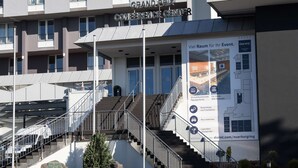The Grand Prix Conference Center with a staircase leading to the entrance, a banner with event information, and a modern building facade.