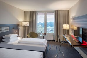 Relax in a spacious room with a large bed, flat-screen TV, and city views.