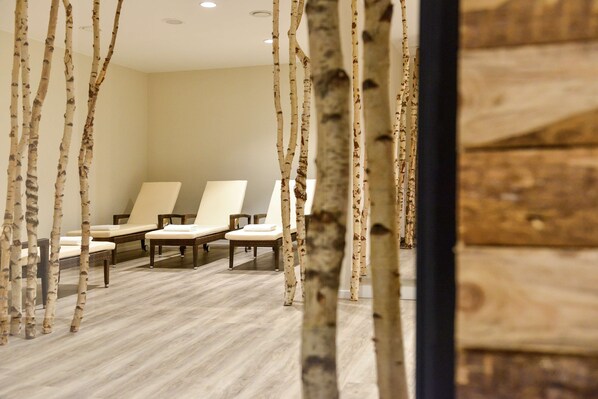 A room with birch tree decor, three white cushioned chairs, and a wooden floor. - Dorint Am Nürburgring Hocheifel (Nuerburg)