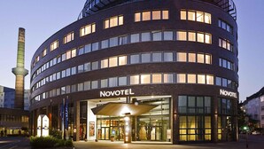 A Novotel hotel with a curved facade, multiple floors, and a prominent entrance with a canopy. - Novotel Hannover (Hannover)