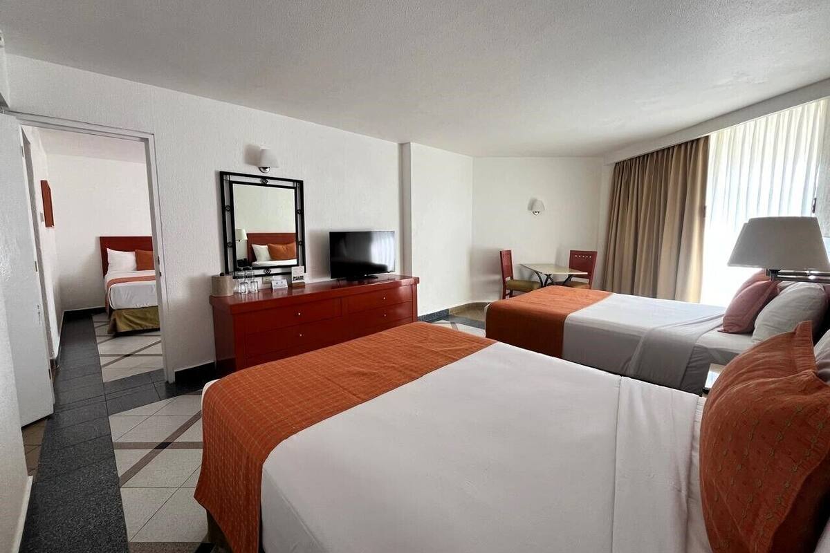Ett hotellrum med två sängar, en TV, ett skrivbord och en stol.
