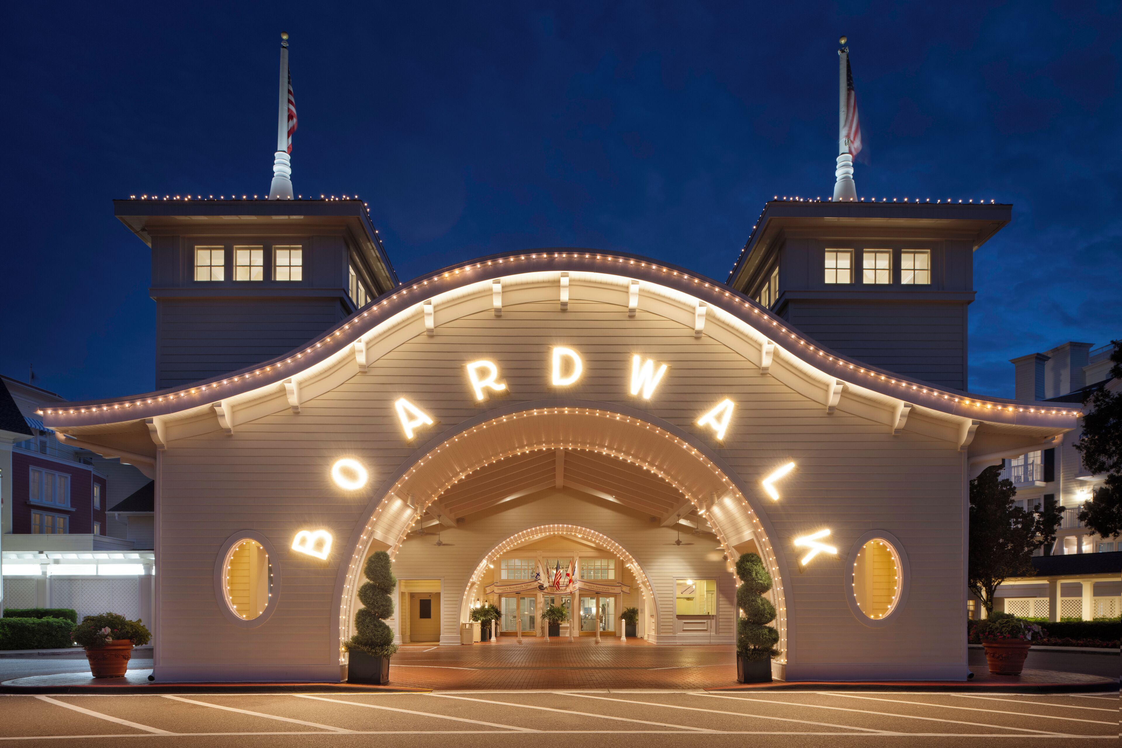 A hotel entrance with a marquee sign, two towers, and a curved roof.