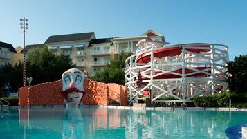 A swimming pool with a water slide and a clown face decoration.