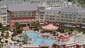 Un complexe hôtelier comprenant plusieurs bâtiments, un espace piscine central et un toboggan aquatique.