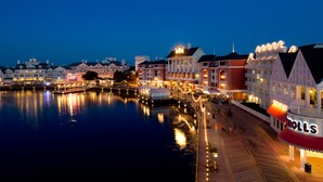 A waterfront hotel with multiple buildings, a boardwalk, and a sign for 'Rolls'.