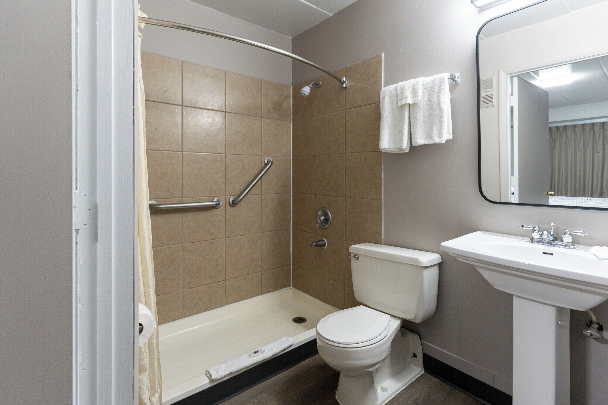 Un baño con ducha, inodoro y lavamanos.