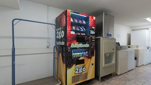 A vending machine labeled 'Smart Snacks' with a price of $2.00, located in a hallway with a cart and a washing machine.