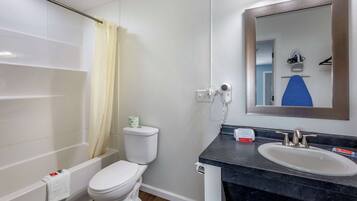 A bathroom with a bathtub, toilet, and sink.