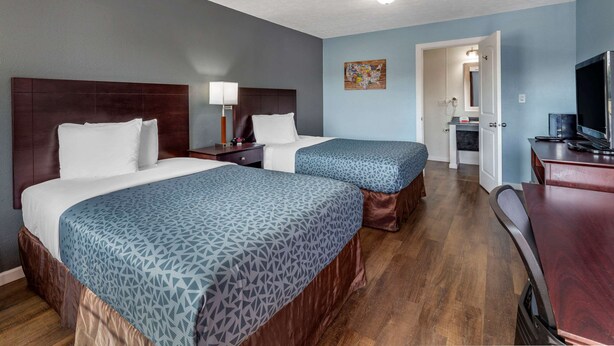 A hotel room with two beds, a desk, a chair, a TV, and a bathroom visible through an open door. - Econo Lodge Inn & Suites Sandusky South (Sandusky)