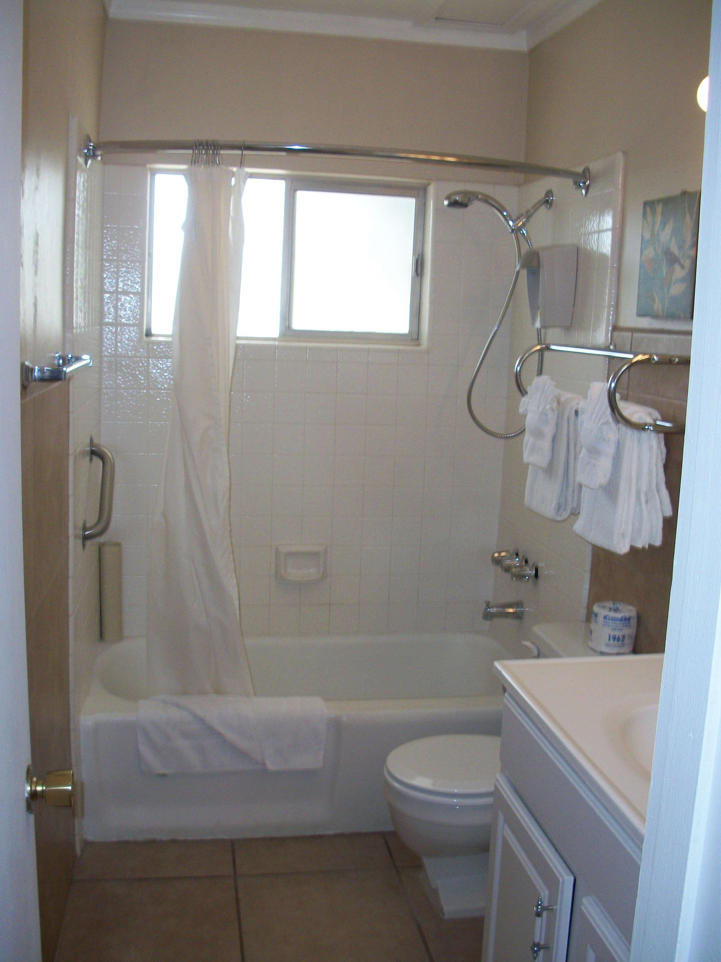 A bathroom with a bathtub, toilet, and sink.