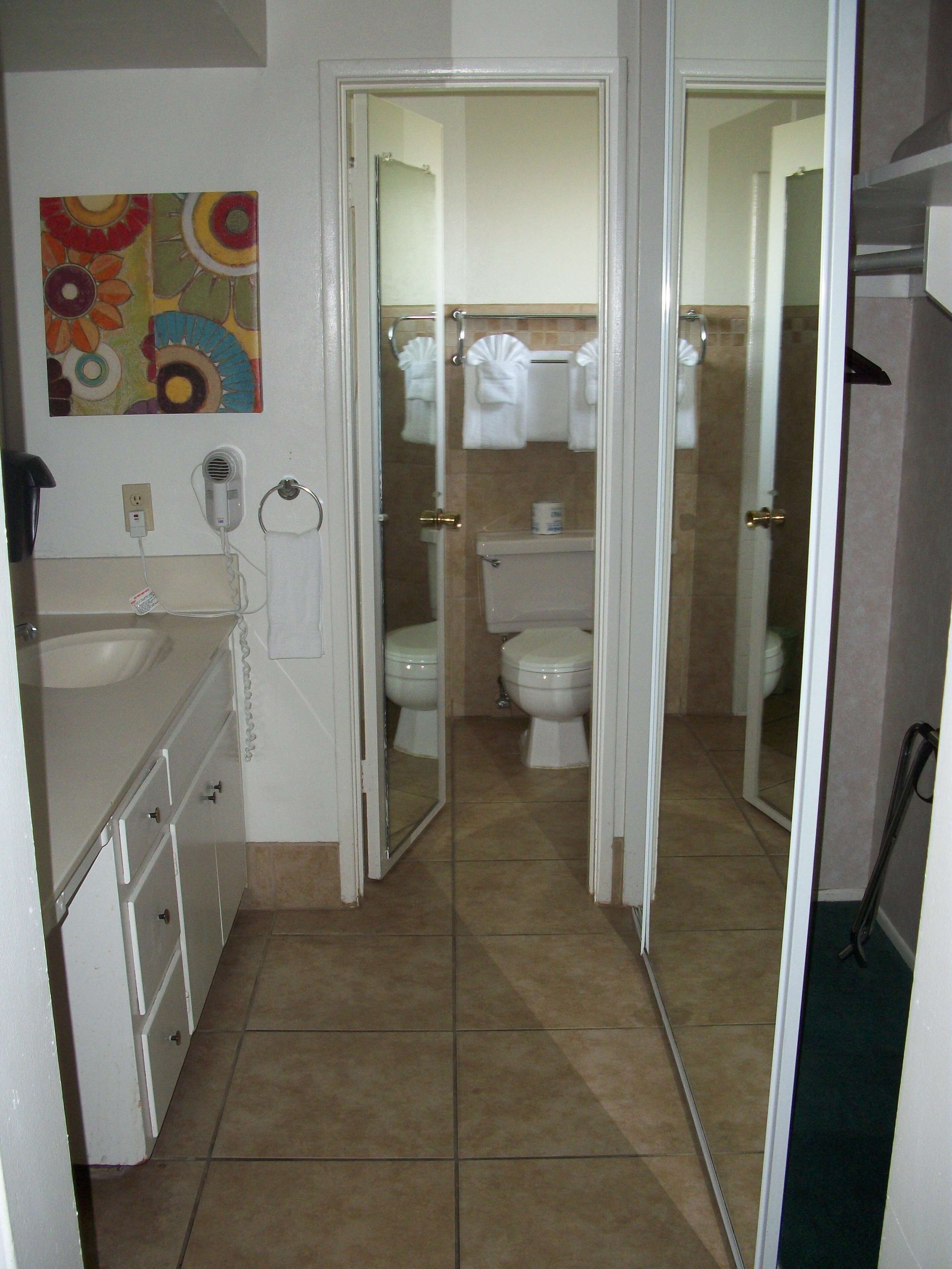 Un baño con inodoro, lavamanos y zona de ducha.