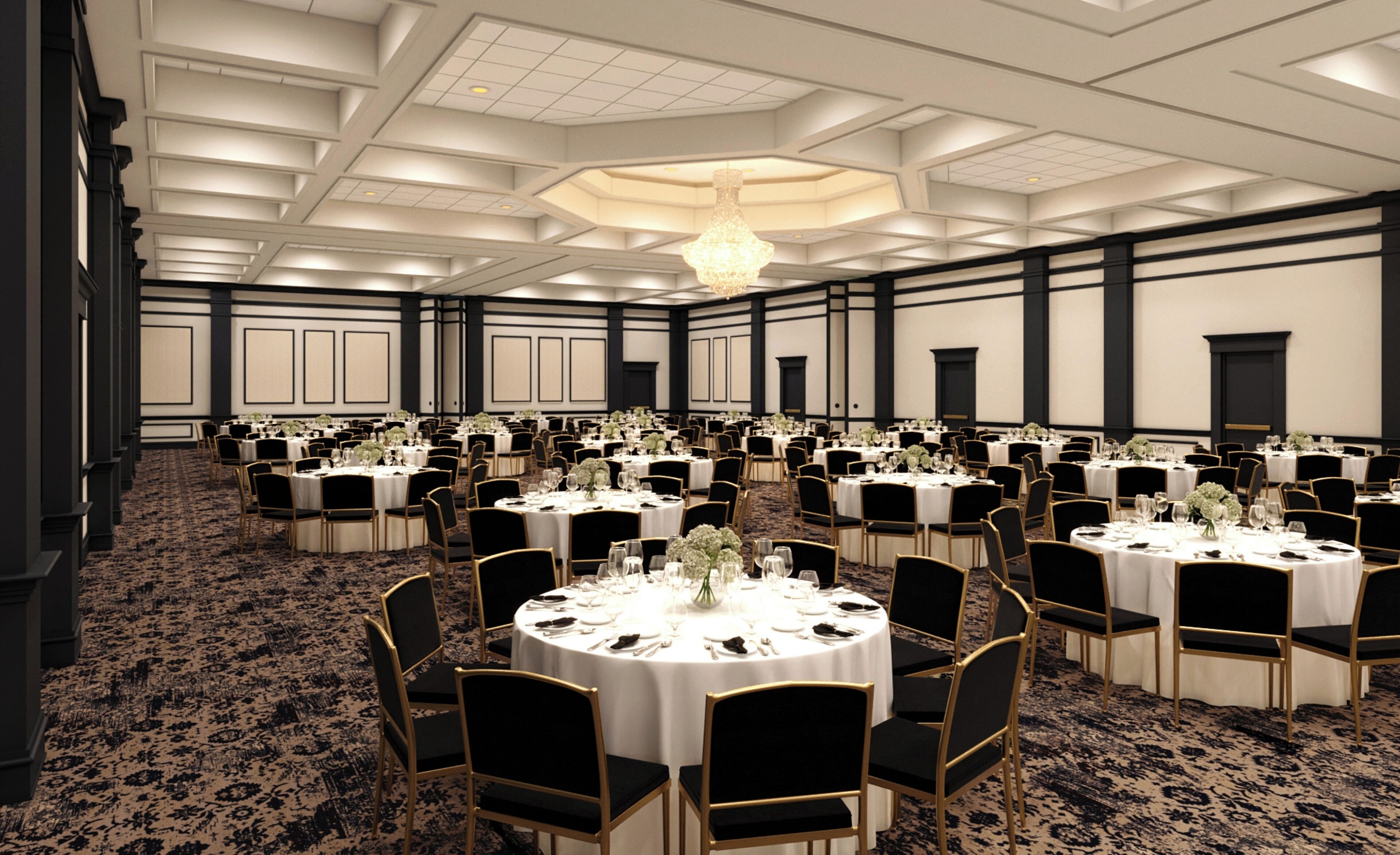 Une grande salle de banquet avec des tables rondes, des chaises noires et des nappes blanches.