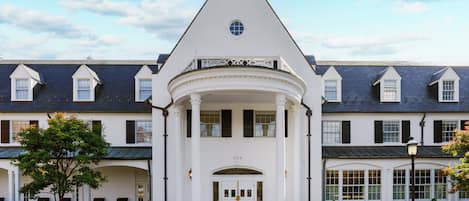 A white building with a central entrance, multiple windows, and a number "200" above the doors.