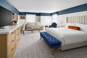 Una habitación de hotel con cama, sofá, escritorio y silla.